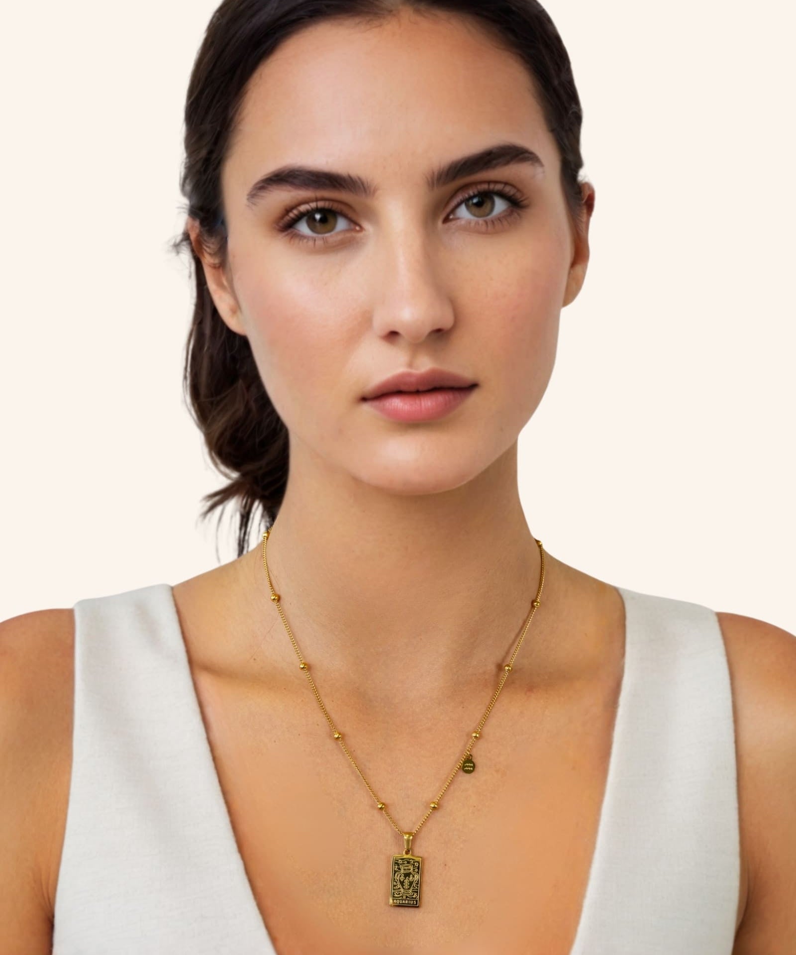 Aquarius Gold Zodiac Tag Necklace by Lavana, on model engraved tag on beaded chain, front