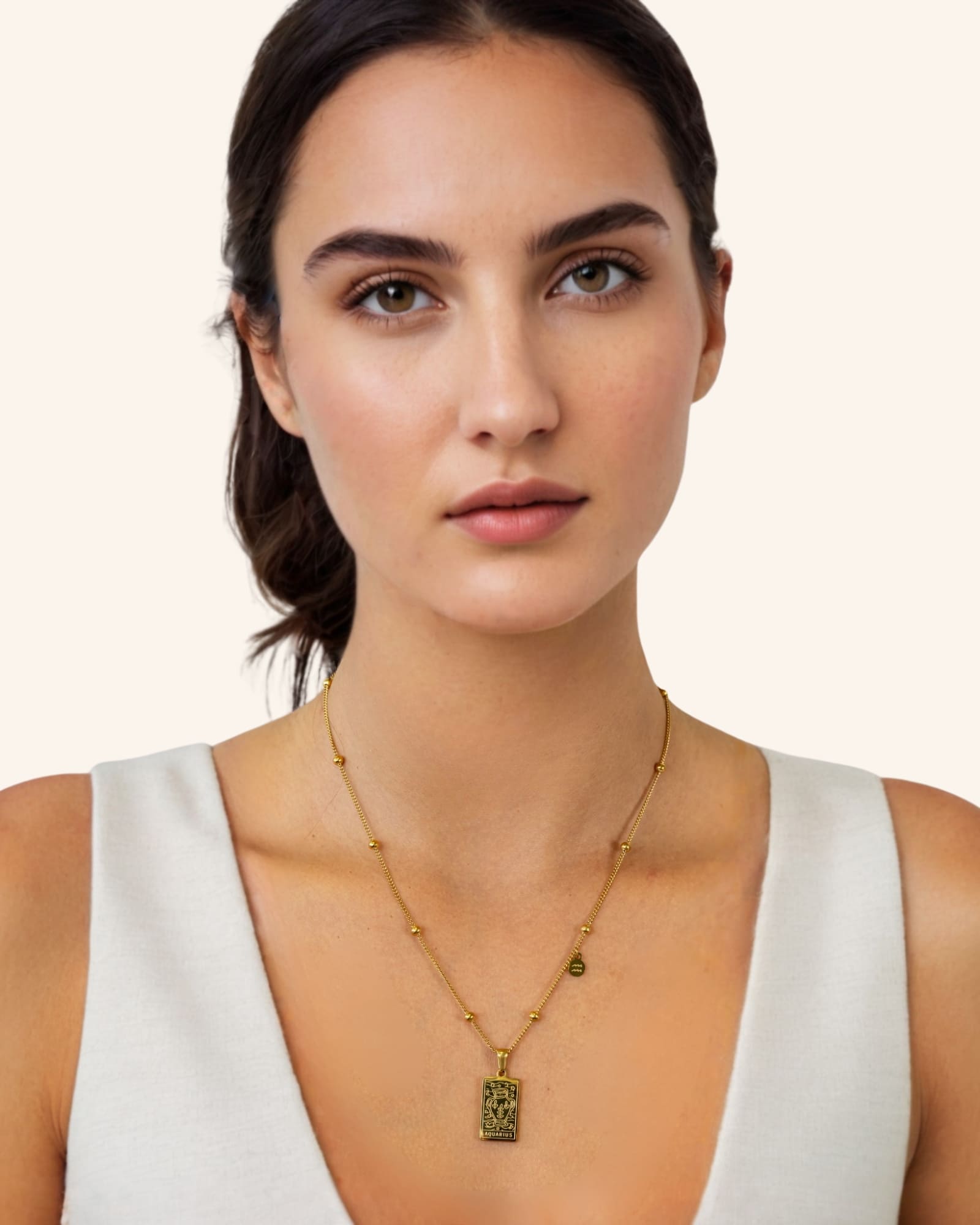 Aquarius Gold Zodiac Tag Necklace by Lavana, on model engraved tag on beaded chain, front