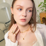 Aura Gold Hoop Earrings by LAVANA, on model wide medium dress hoops with angled light catching detail