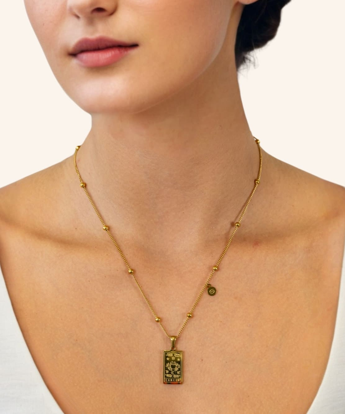 Cancer Gold Zodiac Tag Necklace by Lavana, on model engraved tag with constellation on beaded front