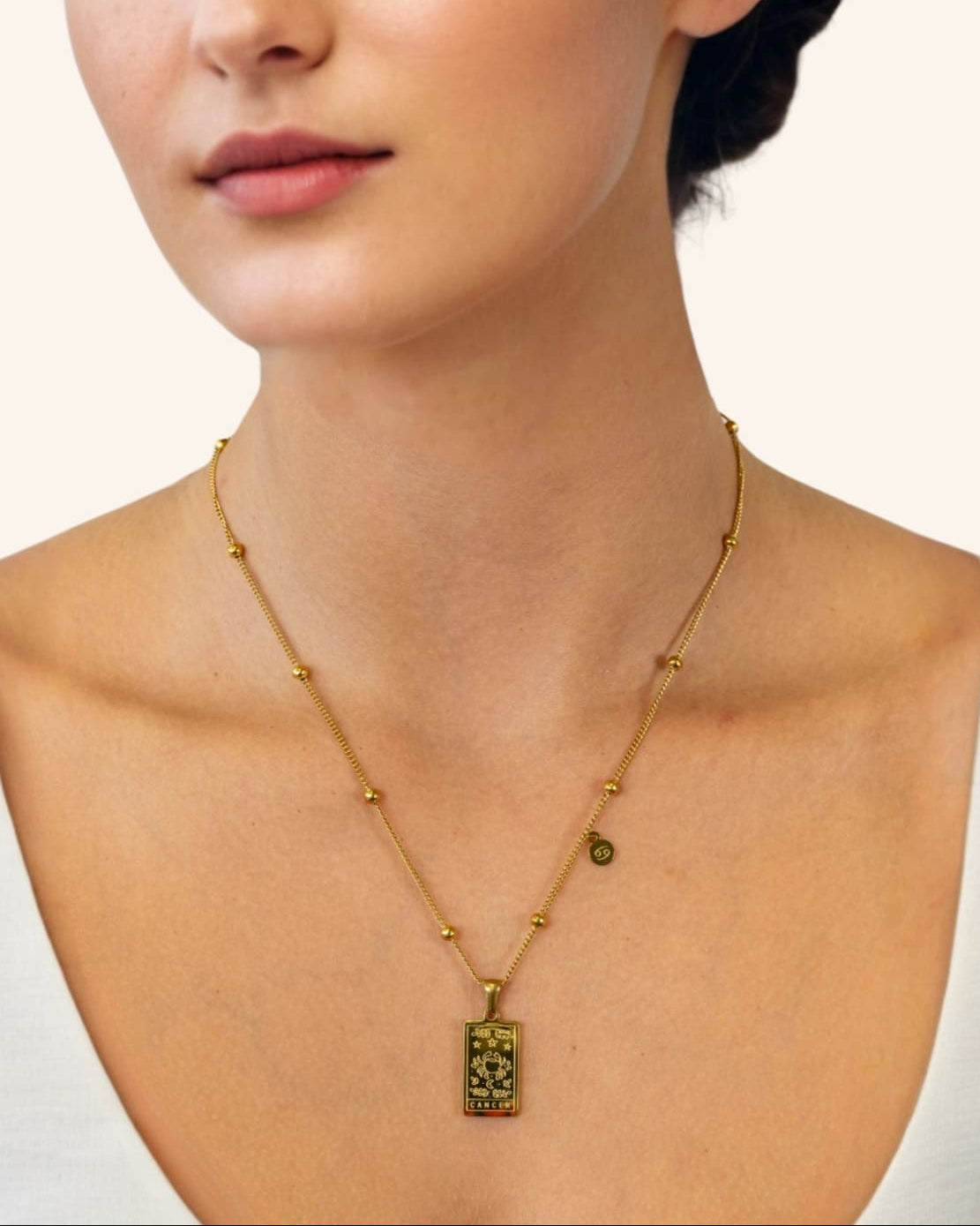 Cancer Gold Zodiac Tag Necklace by Lavana, on model engraved tag with constellation on beaded front