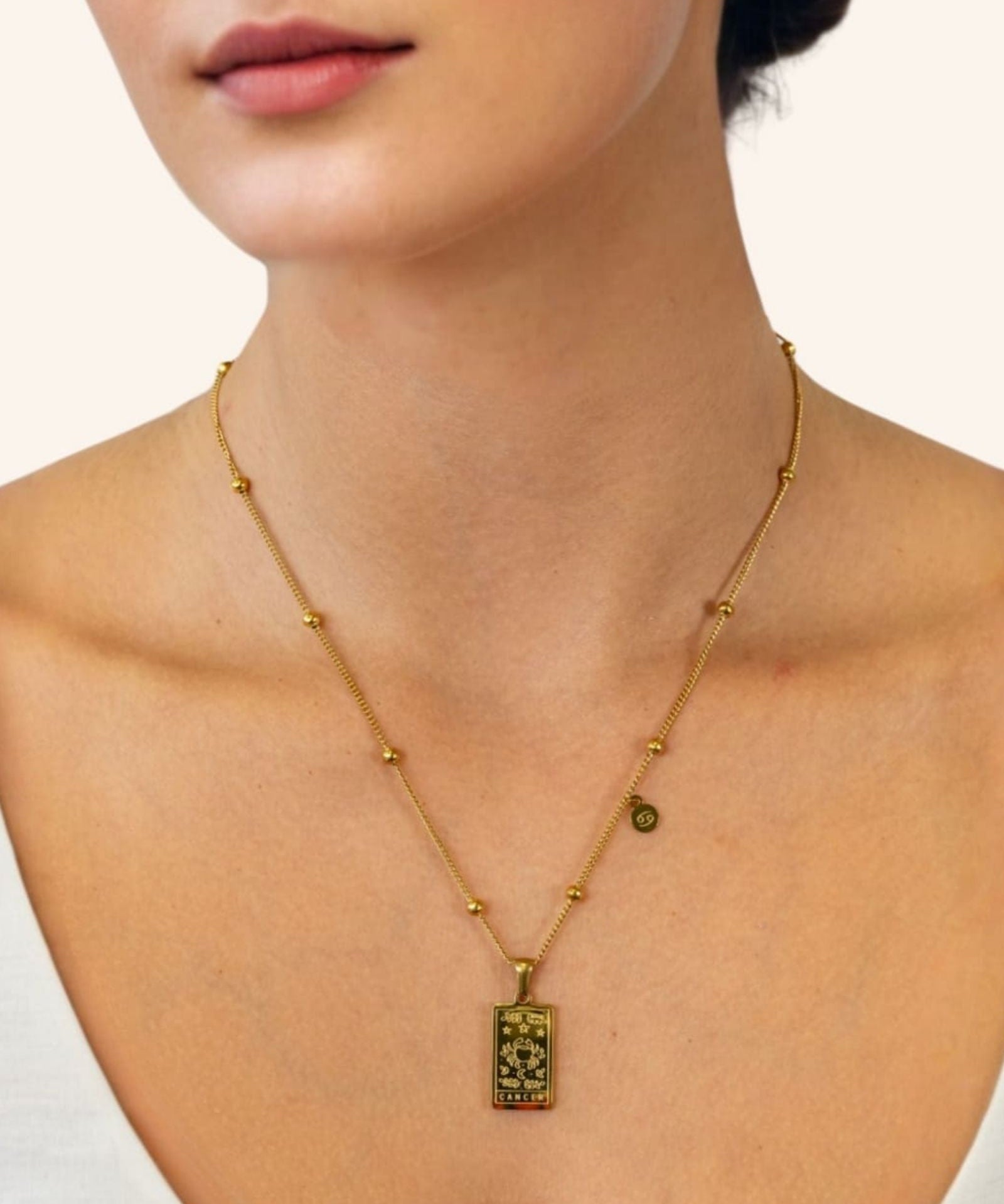 Cancer Gold Zodiac Tag Necklace by Lavana, on model engraved tag with constellation on beaded front