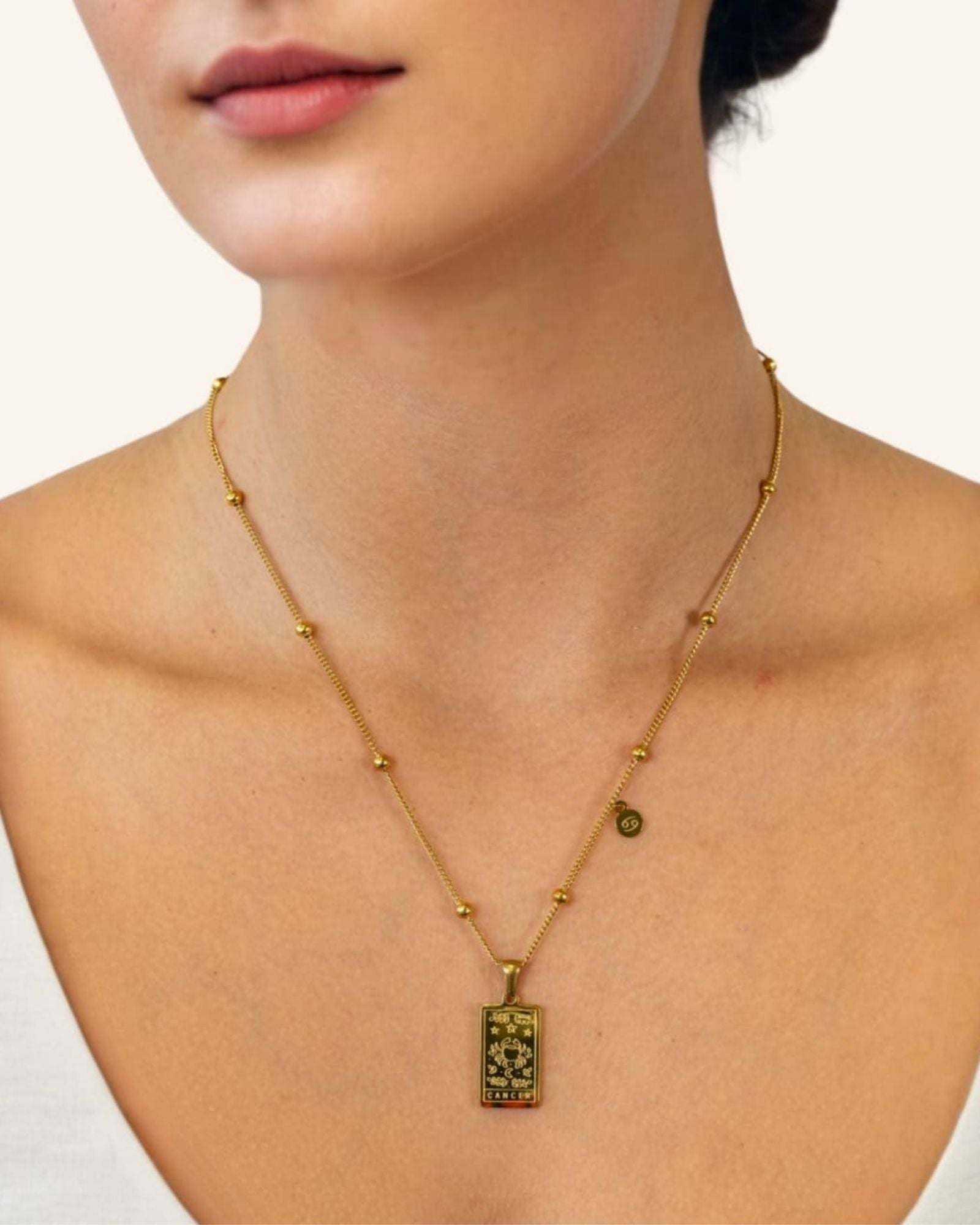 Cancer Gold Zodiac Tag Necklace by Lavana, on model engraved tag with constellation on beaded front