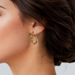 Dance Gold Hoop Earrings Large by Lavana on model slim ribbon twist hoop with polished finish