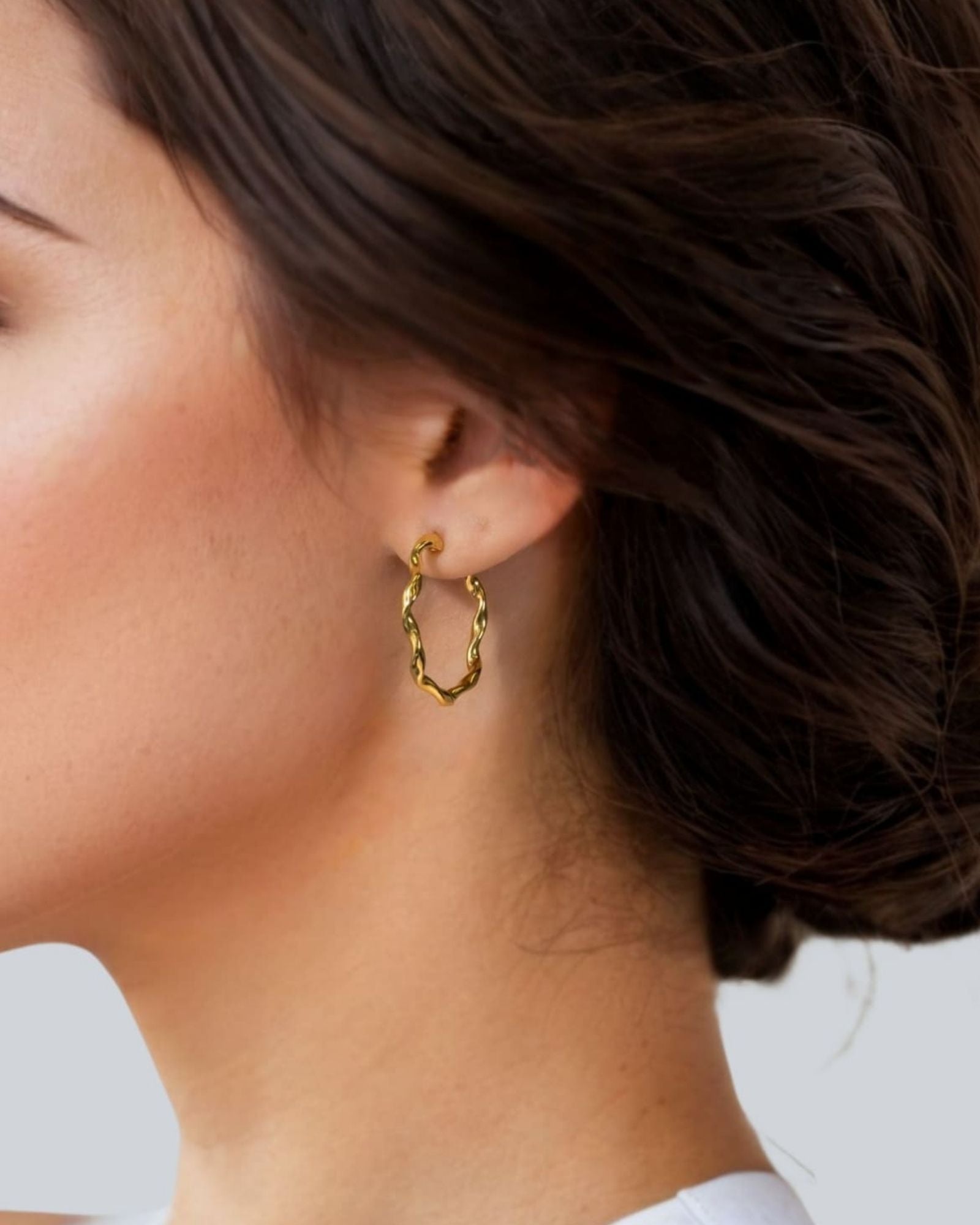 Dance Gold Hoop Earrings Large by Lavana on model slim ribbon twist hoop with polished finish