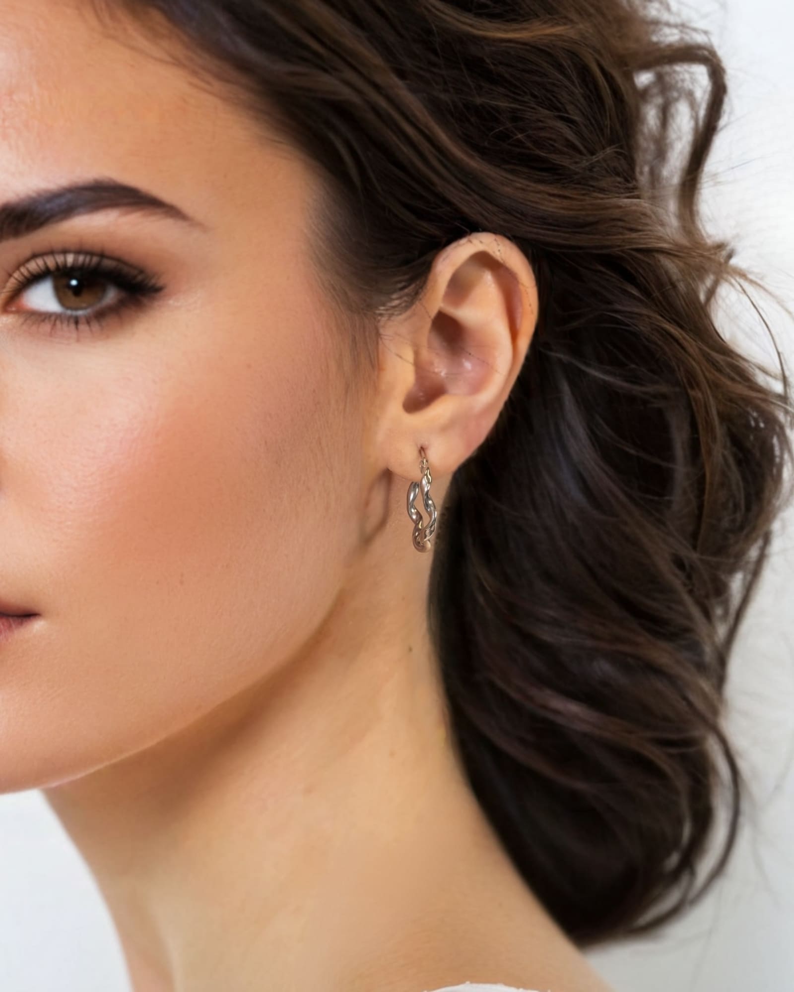 Dance Silver Hoop Earrings Large by Lavana on model slim ribbon twist hoop with polished finish