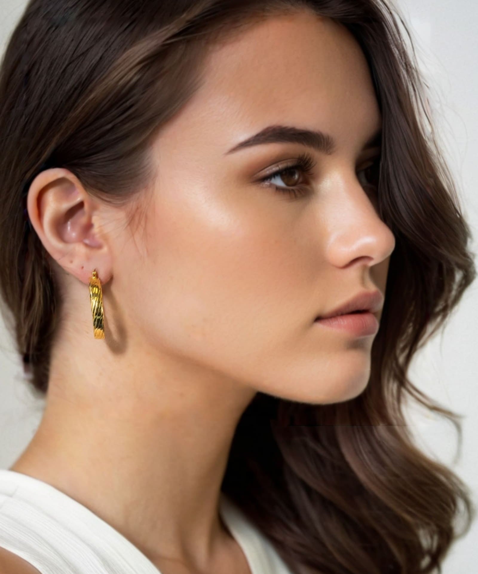 Drift Gold Hoop Earrings by Lavana on model wide polished hoops with deep groove texture