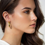 Drift Gold Hoop Earrings by Lavana on model wide polished hoops with deep groove texture