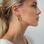 Drift Gold Hoop Earrings by Lavana on model wide polished hoops with deep groove texture