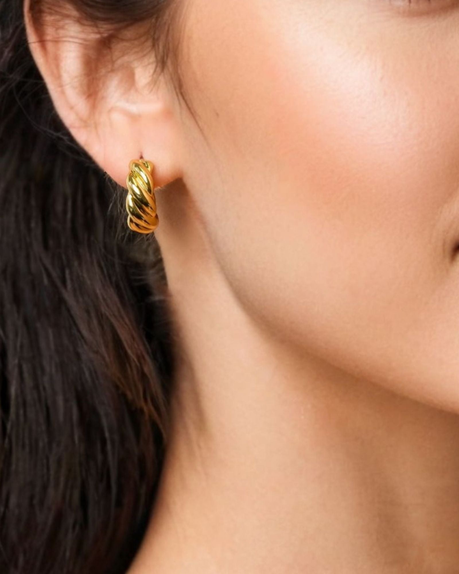 Eve Twist Gold Hoop Earrings by LAVANA on model compact huggie hoop with intertwined twist
