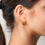 Eve Twist Gold Hoop Earrings by LAVANA on model compact huggie hoop with intertwined twist