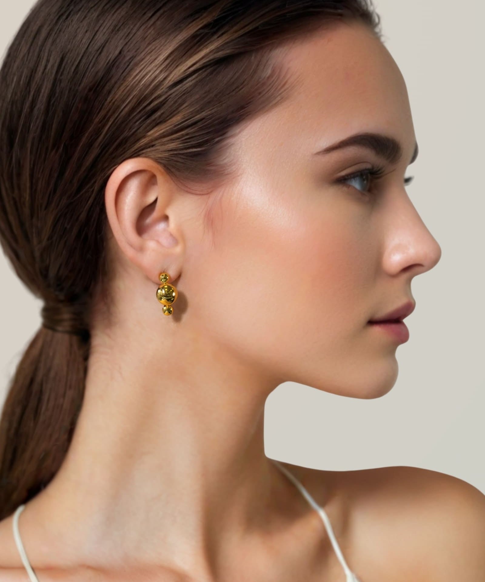 Floating Pebble Gold Huggie Earrings by Lavana on model smooth pebble domes with cool gloss