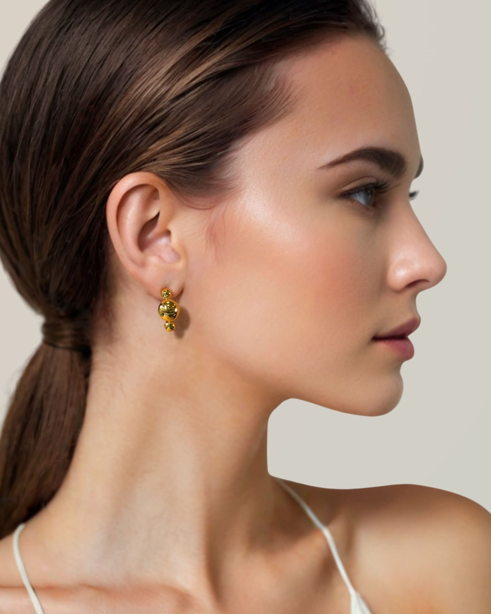 Floating Pebble Gold Huggie Earrings by Lavana on model smooth pebble domes with cool gloss