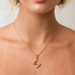 Fluid Gold Pendant by LAVANA on model with sculptural wave silhouette