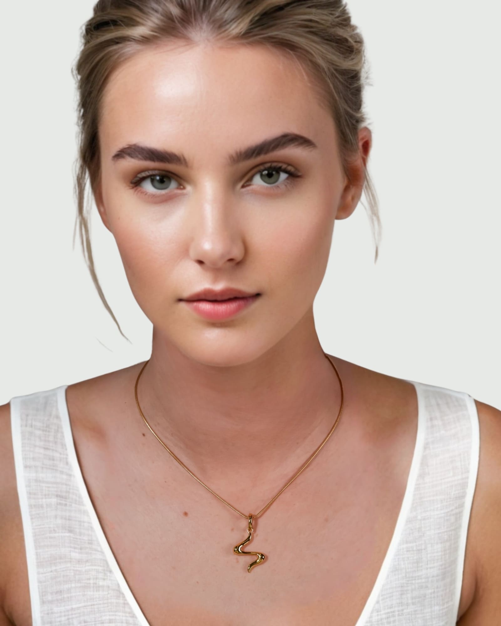 Fluid Gold Pendant by Lavana on model with sculptural wave silhouette