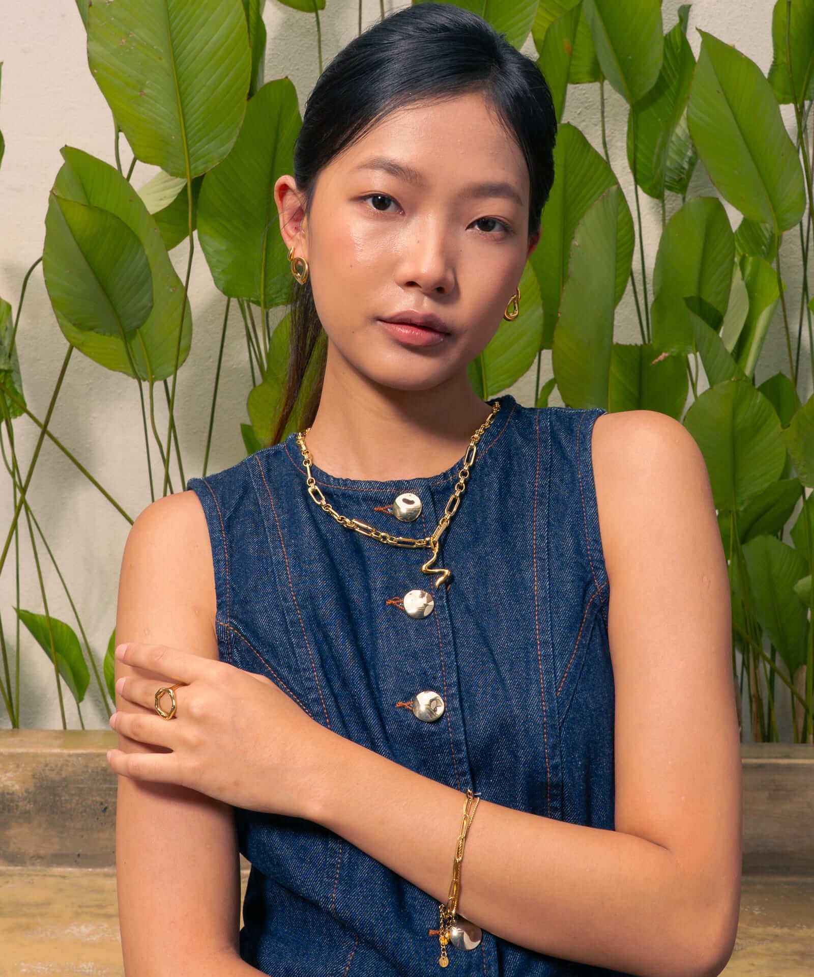 Fluid gold pendant by Lavana, on model; with sculptural wave silhouette