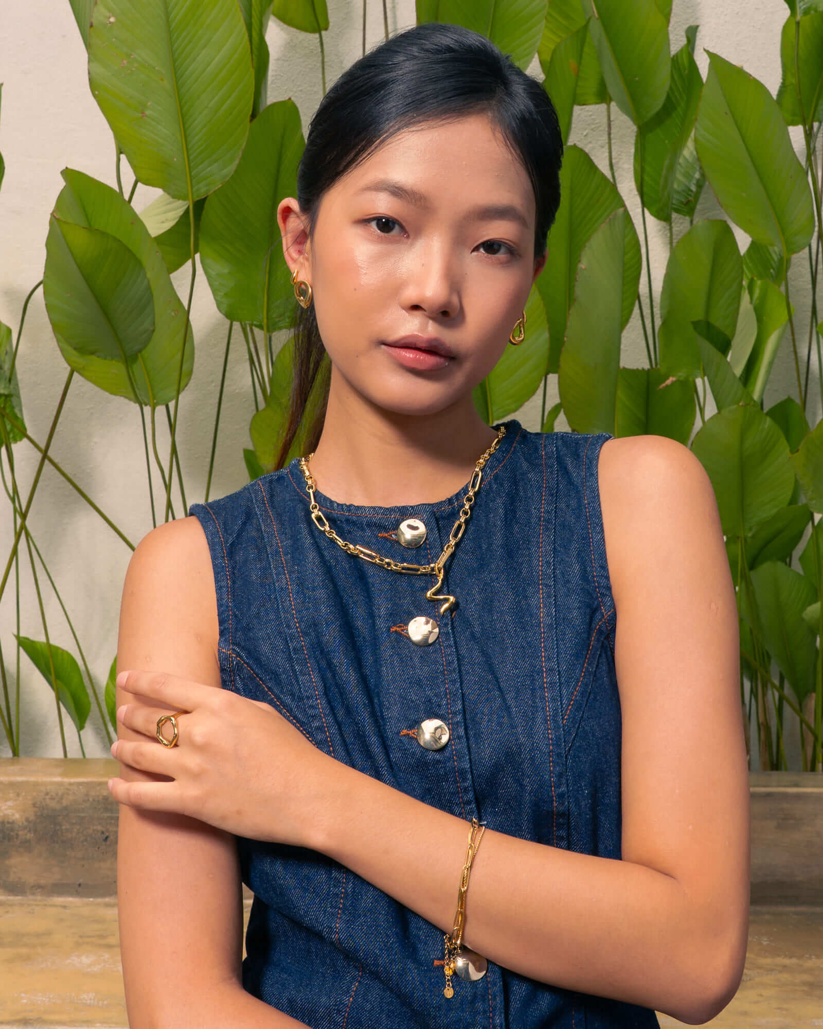 Fluid gold pendant by Lavana, on model; with sculptural wave silhouette