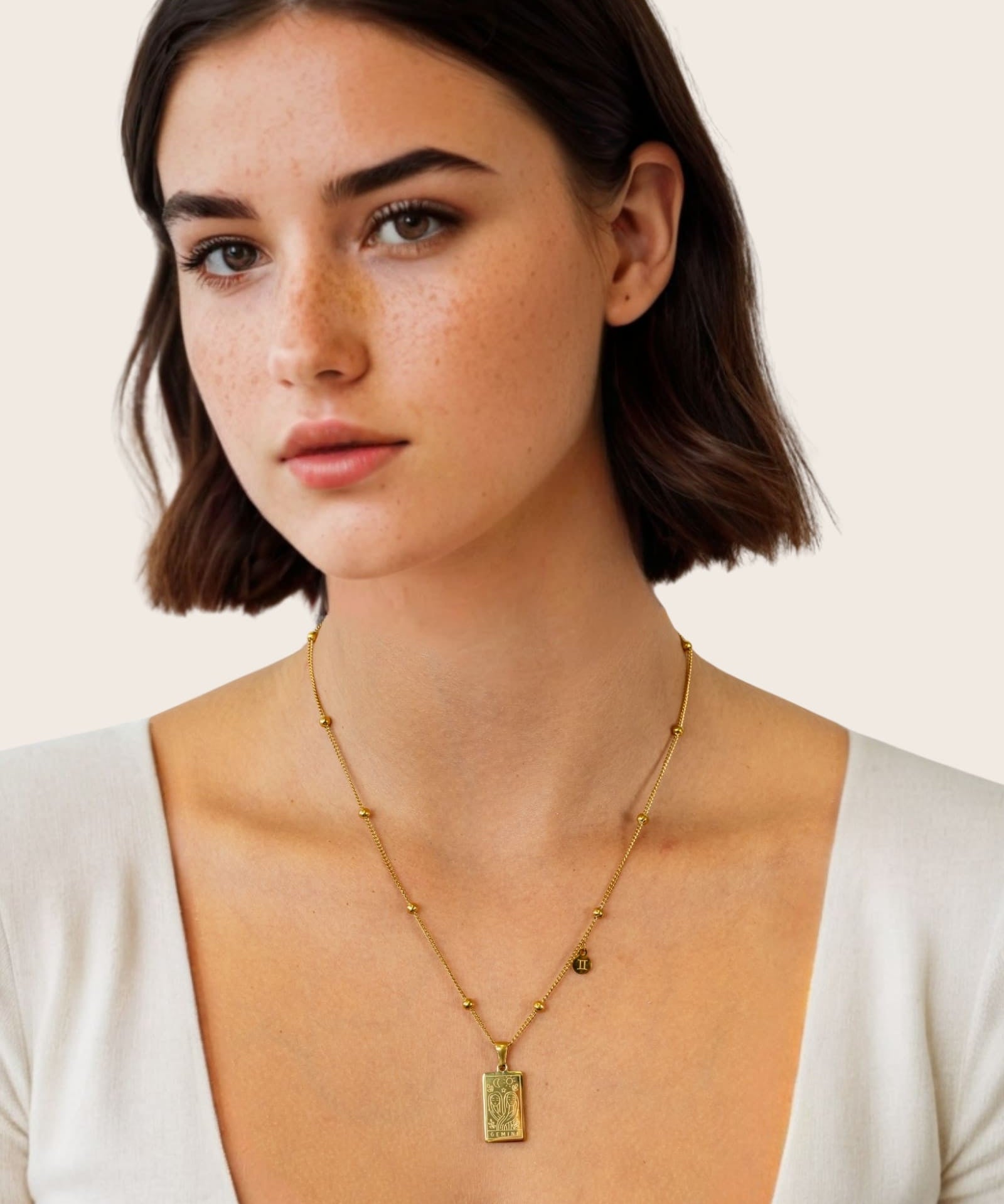 Gemini Gold Zodiac Tag Necklace by Lavana, on model; engraved tag front and back on beaded chain