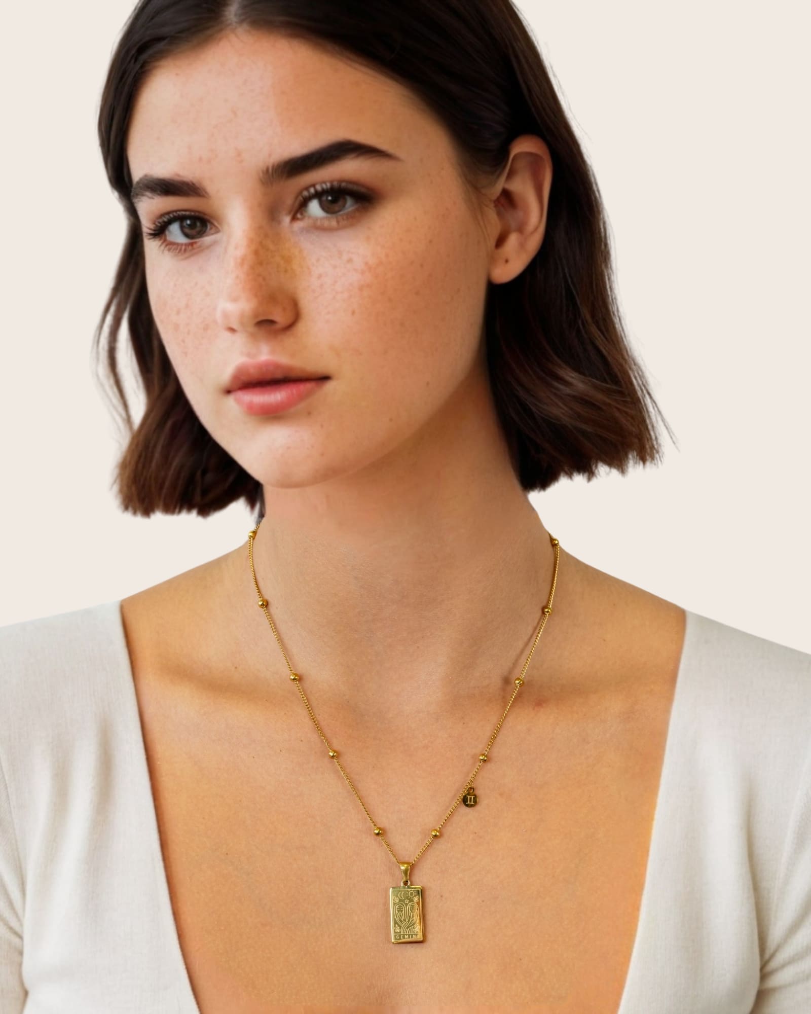 Gemini Gold Zodiac Tag Necklace by Lavana, on model; engraved tag front and back on beaded chain