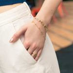 Lavana Signature bracelet on model; with gold logo motif modern link polished finish