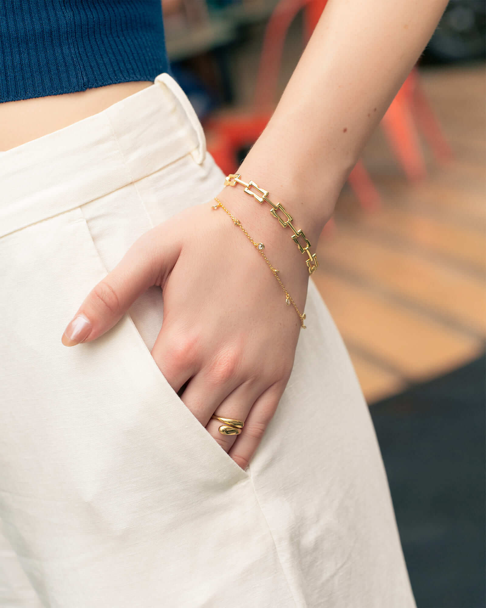 Lavana Signature bracelet on model; with gold logo motif modern link polished finish