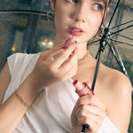 Lavana Signature gold bangle by Lavana, on model; with modern sculpted logo motif links