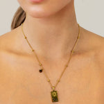 Leo Gold Zodiac Tag Necklace by Lavana, on model; engraved tag with constellation on beaded chain, back