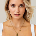 Libra Gold Zodiac Tag Necklace by Lavana, on model; engraved tag with constellation on beaded chain, front