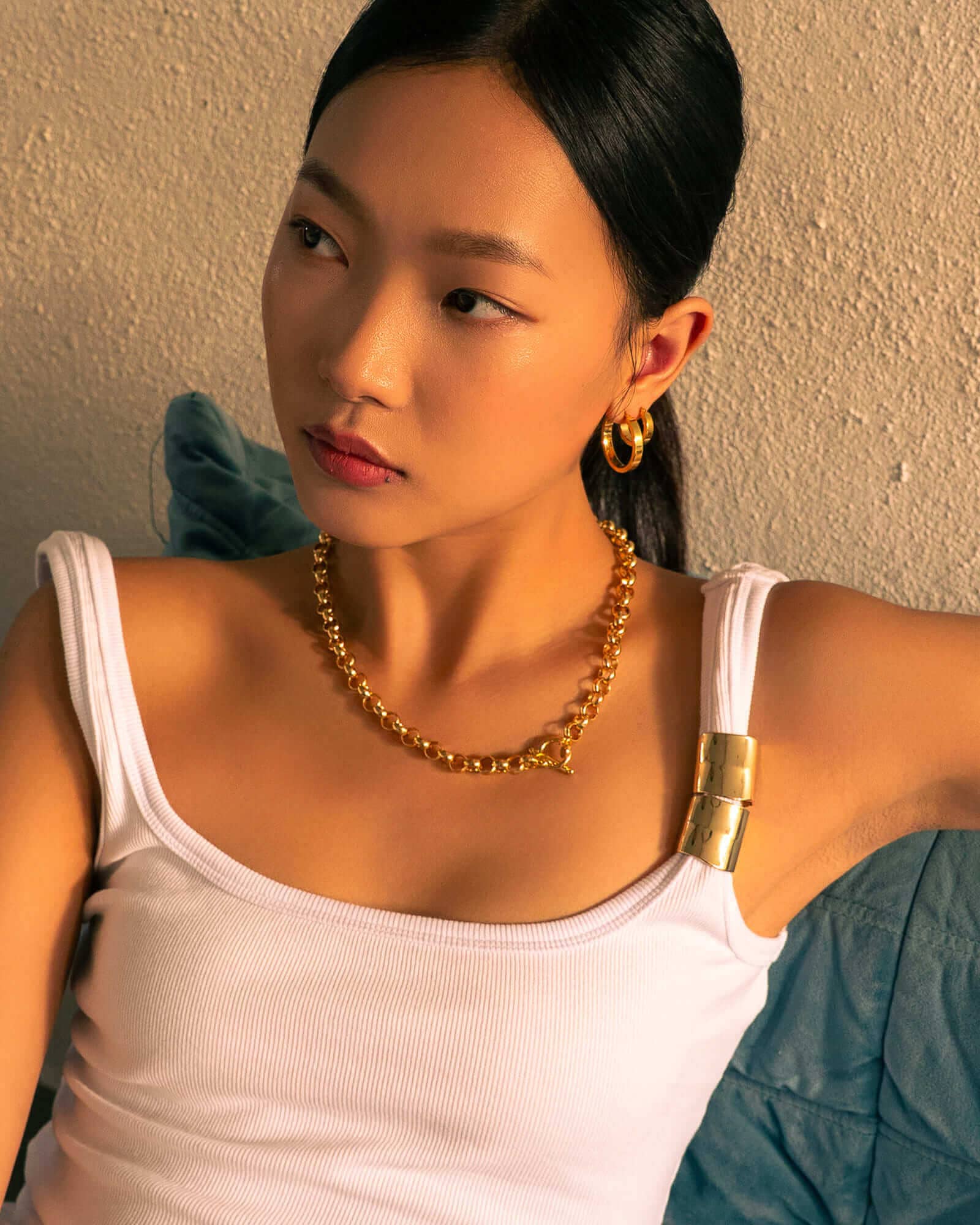 Luna Gold L Hoop Earrings by Lavana, on model; polished classic 4mm dress hoops available in four sizes