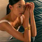Luna Gold S Hoop Earrings by Lavana, on model; polished classic 4mm dress hoops available in four sizes