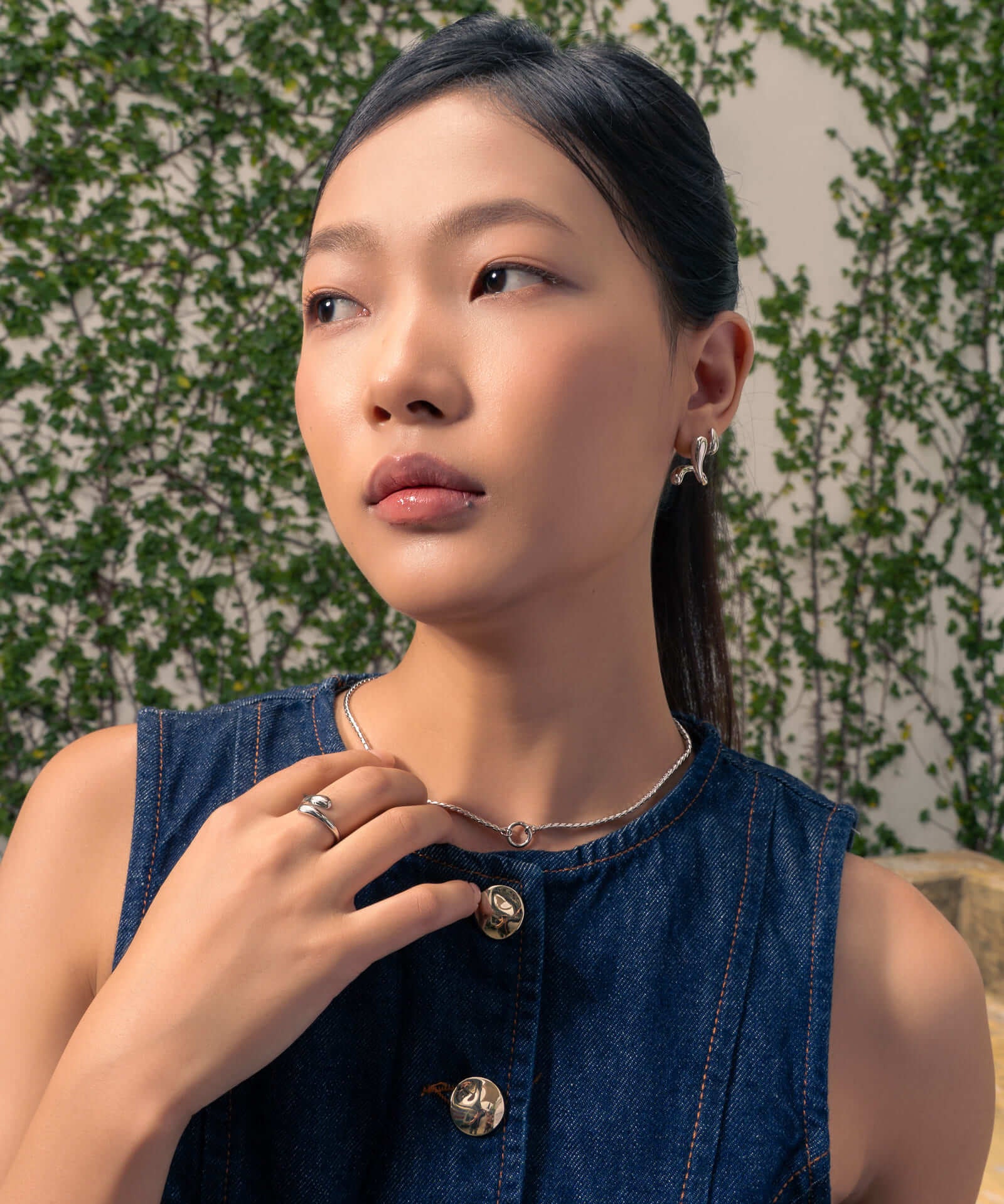 Molten Curve Silver Stud Earrings by LAVANA, on model; polished sculptural curved studs 