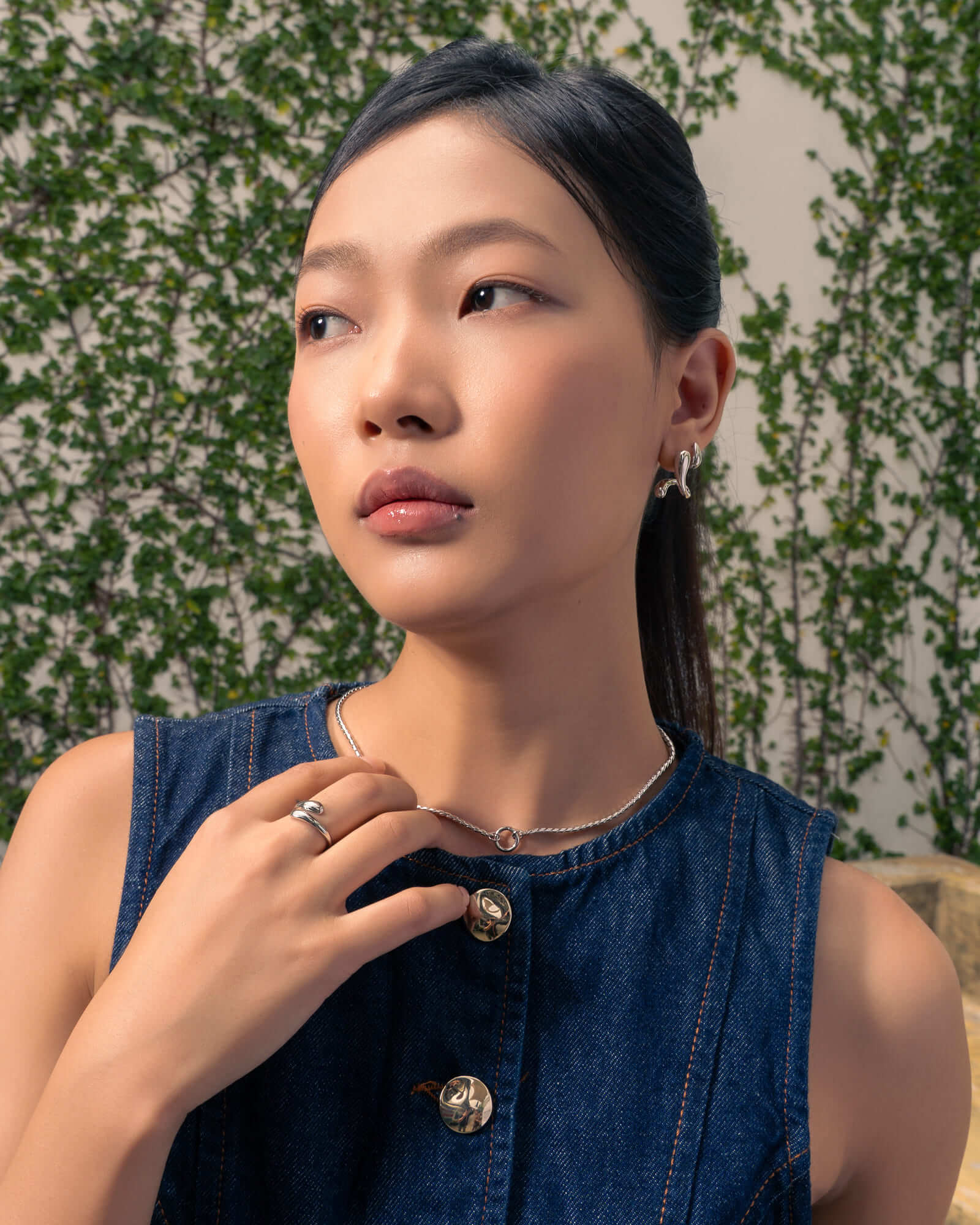 Molten Curve Silver Stud Earrings by LAVANA, on model; polished sculptural curved studs 