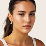 Mondello Gold Pearl Drop Earrings by Lavana, on model; textured organic circle with freshwater pearl drop