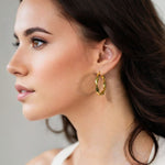Musica Gold Hoop Earrings by Lavana on model extra large round hoops with fluid twist movement