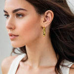 Musica Gold Hoop Earrings by Lavana on model extra large round hoops with fluid twist movement