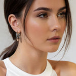 Musica Silver Hoop Earrings by Lavana on model extra large round hoops with fluid twist movement