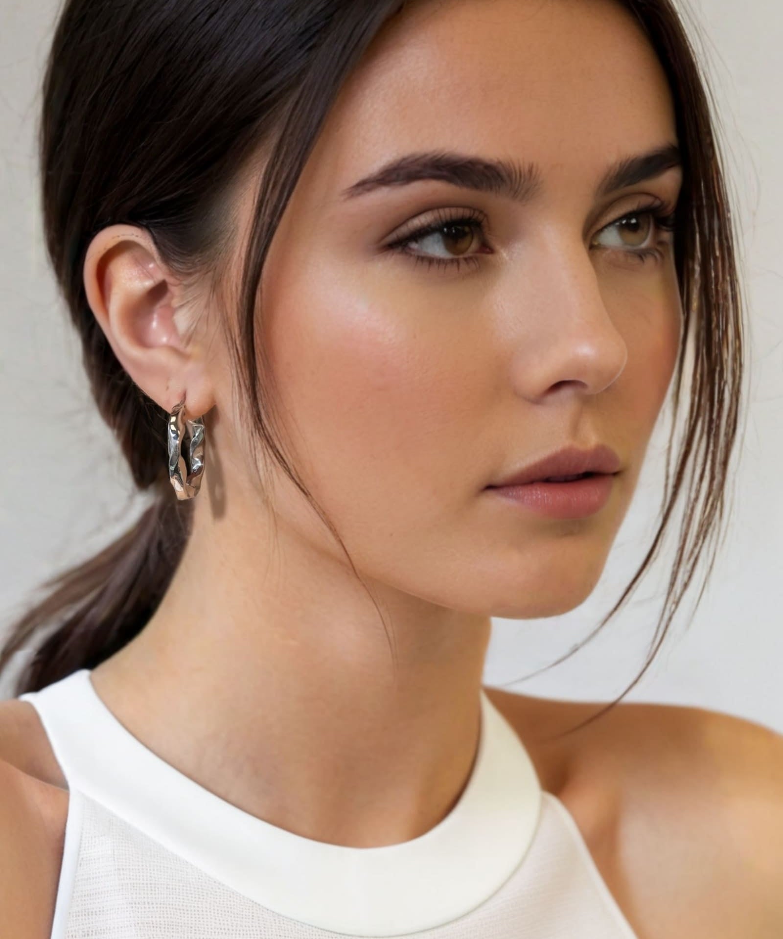 Musica Silver Hoop Earrings by Lavana on model extra large round hoops with fluid twist movement