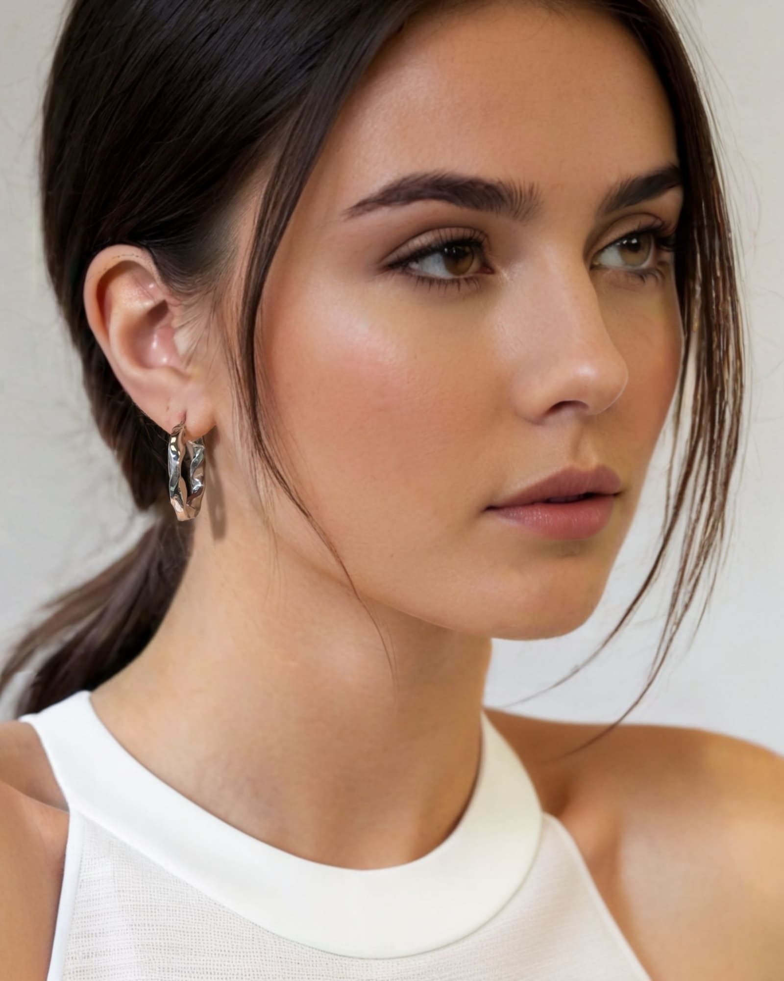 Musica Silver Hoop Earrings by Lavana on model extra large round hoops with fluid twist movement