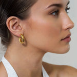 Oceania Gold Hoop Earrings by Lavana on model open back wide hoops with wave ridge texture