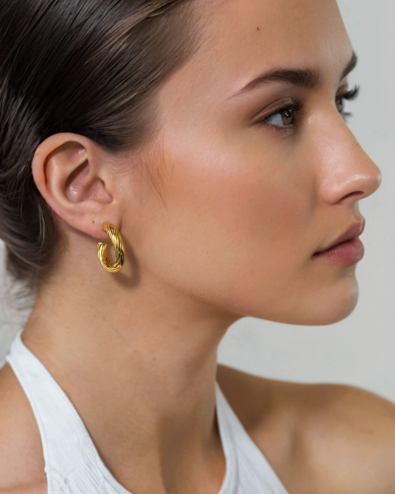 Oceania Gold Hoop Earrings by Lavana on model open back wide hoops with wave ridge texture