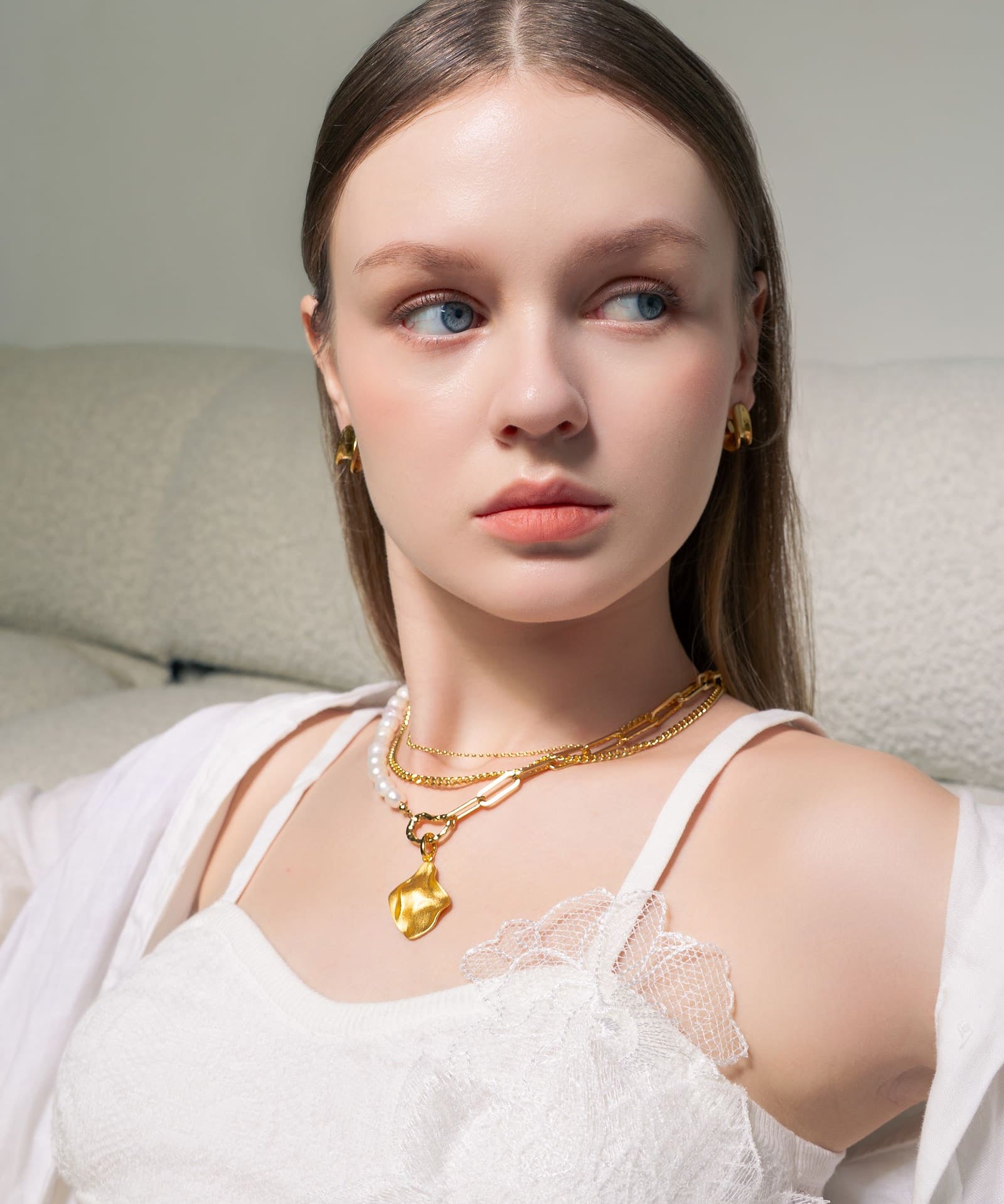 Pearlescent reversible gold pendant by Lavana, on model with modern brushed front and high polish back