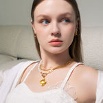 Pearlescent reversible gold pendant by Lavana, on model with modern brushed front and high polish back