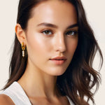 Pebble Pearl Charm Gold Huggie Earrings by Lavana, on model; domed huggies with three freshwater pearl charms