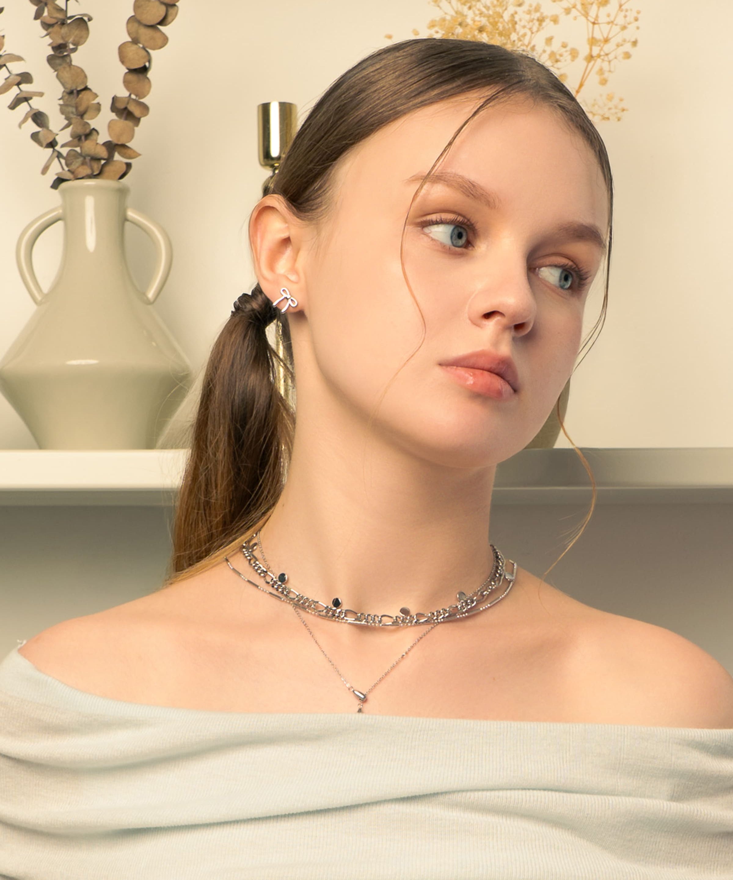 Petite Bow Silver Stud Earrings by LAVANA, on model tiny polished classic ribbon bow design