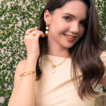 Positano gold pearl necklace by Lavana, on model; asymmetric paperclip links with baroque pearl drop 
