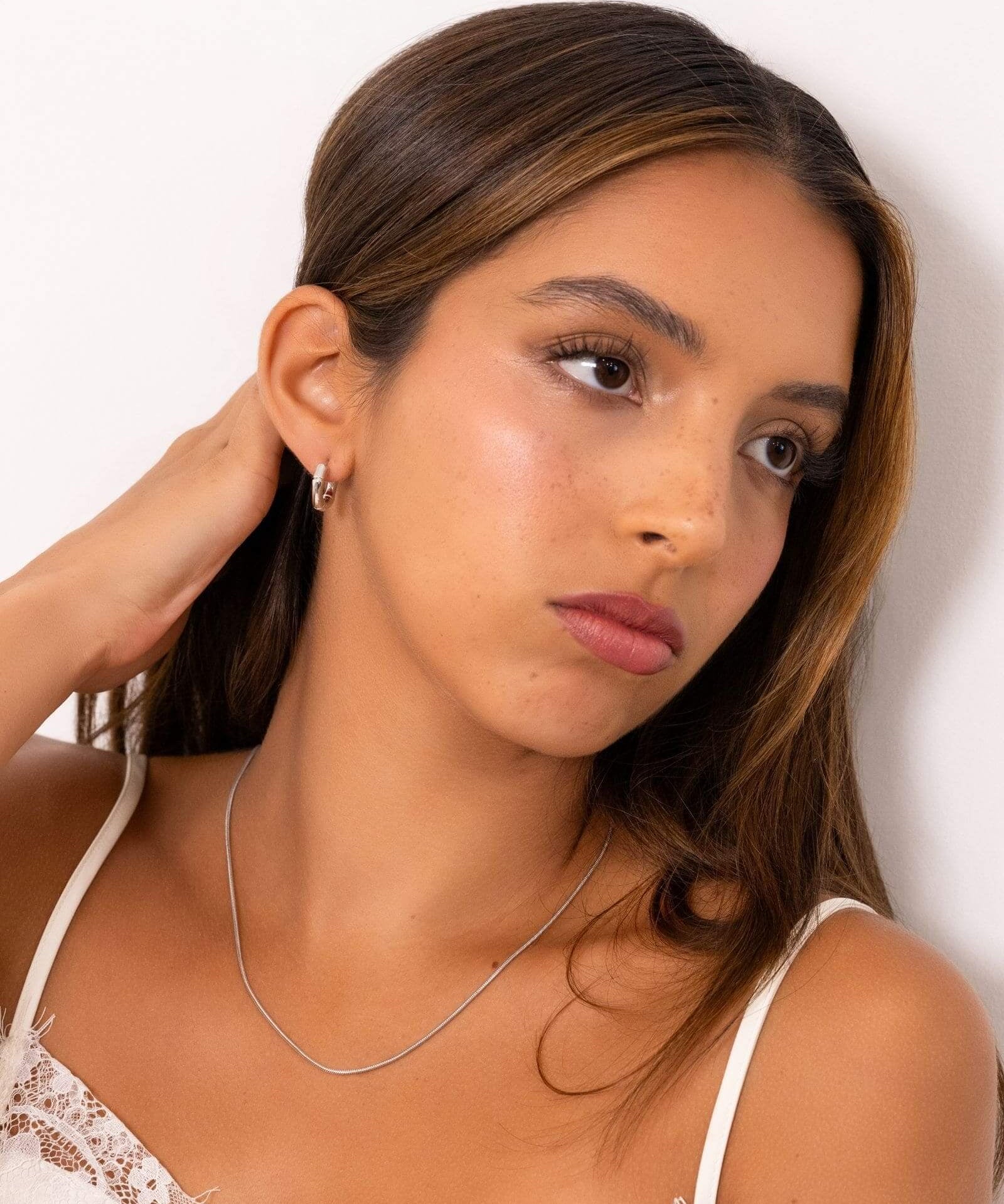 Prosperity Bamboo Gold Huggie Earrings by Lavana on model bamboo textured ridges with a compact thick profile