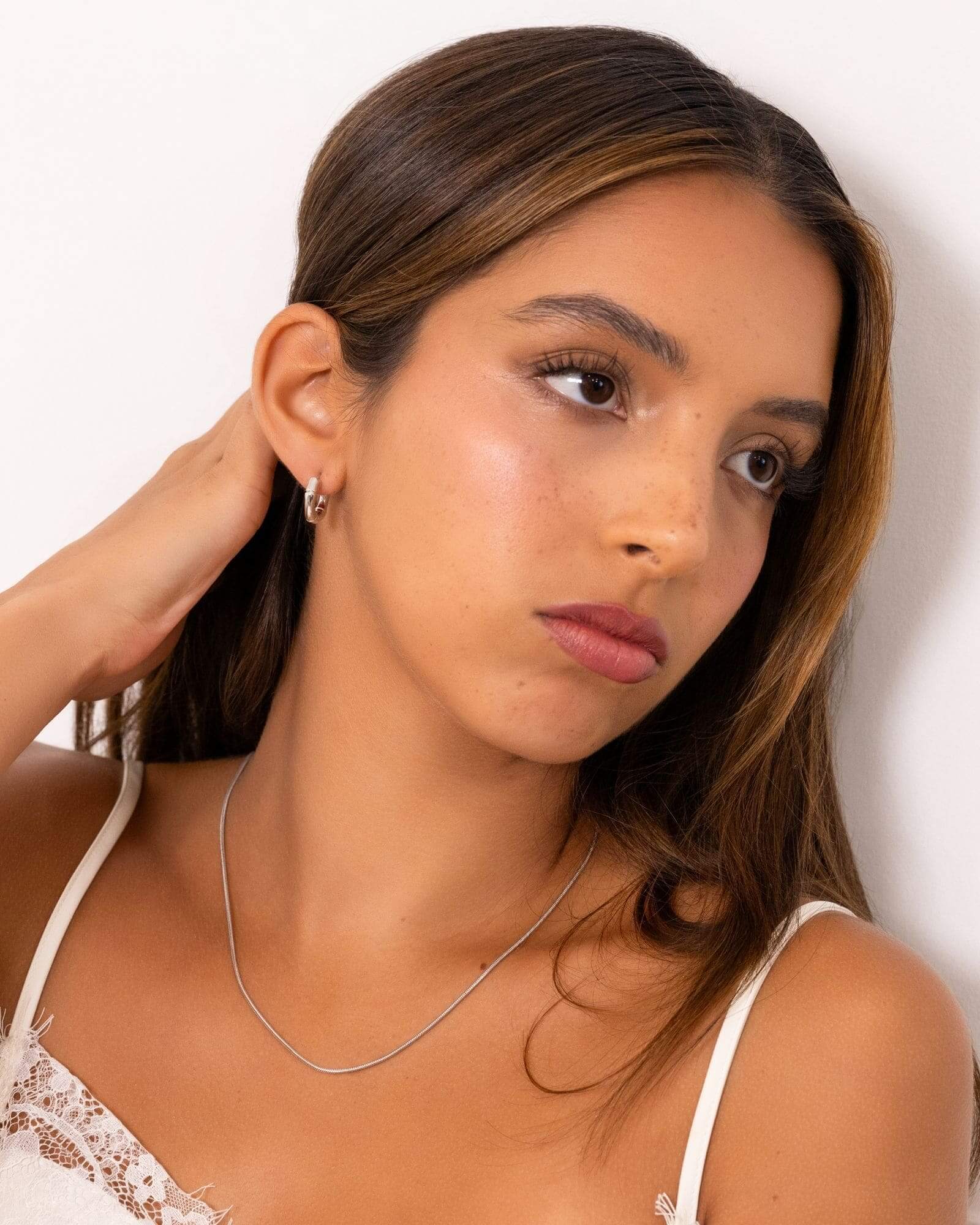 Prosperity Bamboo Gold Huggie Earrings by Lavana on model bamboo textured ridges with a compact thick profile