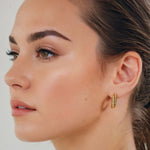 Puffy Croissant Gold Hoop Earrings by Lavana on model polished domed open hoop with croissant shape