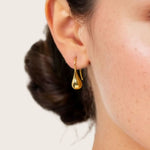 Raindrop Hook Gold Drop Earrings by LAVANA on model polished raindrop silhouette
