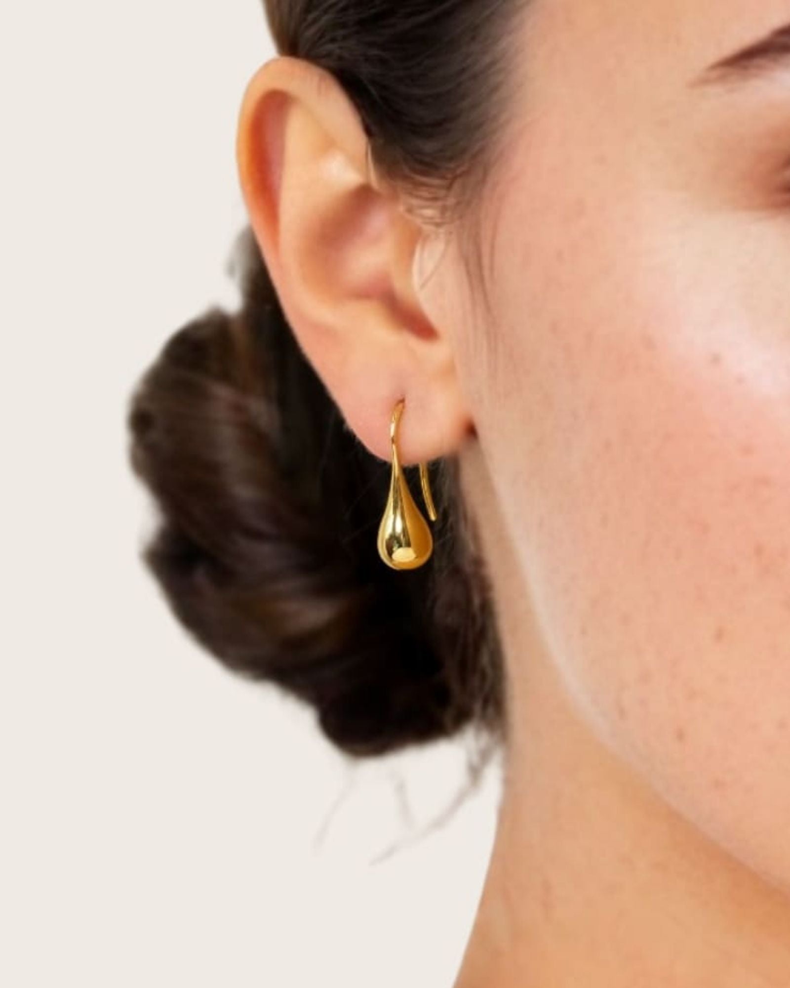 Raindrop Hook Gold Drop Earrings by LAVANA on model polished raindrop silhouette